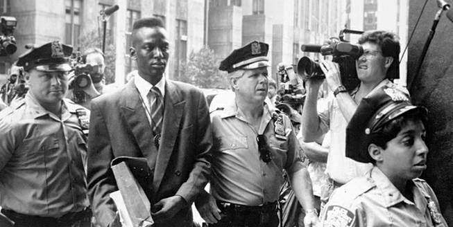 This 1990 file photo provided by Sundance Selects shows accused rapist Yusef Salaam, second right, being escorted by police in New York in 1990. Salaam is the subject of the documentary, "The Central Park Five," about the 1989 case of five black and Latino teenagers who were convicted of raping a white woman in Central Park. A city official said Friday, June 20, 2014 that New York City has agreed to a $40 million settlement in a civil rights lawsuit filed against police and prosecutors by Salaam and four co-defendants exonerated in the notorious case of a jogger attacked in Central Park in 1989.