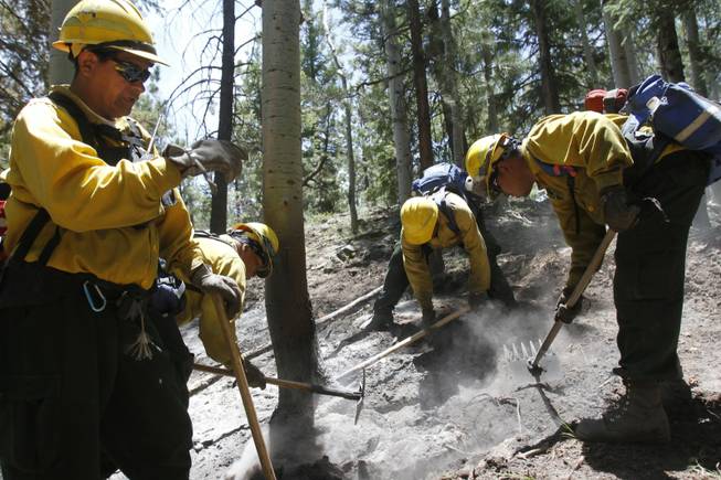 Navajo Scouts Crew Boss Irvin Begay, right, gives instructions to his crew as they take control of the Assayii Lake Fire, Friday, June 20, 2014 near Crystal, N.M. Firefighters have made significant strides in a wildfire that has consumed more than 21 square miles of forest and grazing land on the Navajo Nation.
