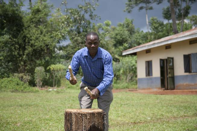 A community leader demonstrates an alert given to the community when a child is abducted using a large drum, in Kampala, Uganda. When a child goes missing, the villagers beat drums into a soaring rhythm that sends rescuers scampering through bushes. Others, riding motorcycles, try to block exit routes. With children being kidnapped and killed in ritual murders, a traumatized community here has created a rudimentary but potentially effective abduction alert system that has saved at least two children this year.