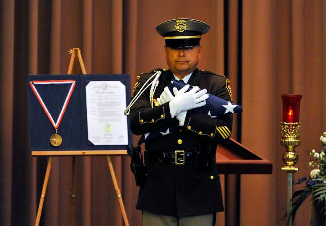 Las Vegas police Lt. Robert Smith of the honor guard presents an American flag during a memorial service for Joseph Wilcox at Palm Downtown Mortuary and Cemetery on Sunday, June 22, 2014. Wilcox, 31, was killed trying to stop Jerad and Amanda Miller in the midst of their shooting spree at an east valley Walmart store on June 8.