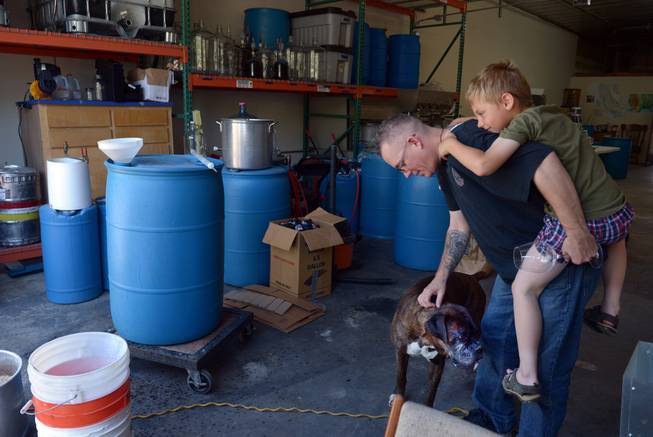 Marine Corps veteran Andy Kulakowski pets Socks at Uncle Sam's Misguided Brewery, with his son Mason Kulakowski hanging on in Livermore, Calif., on Monday, May 26, 2014. Free tastings were part of the brewery and winery's Memorial Day event for all veterans.