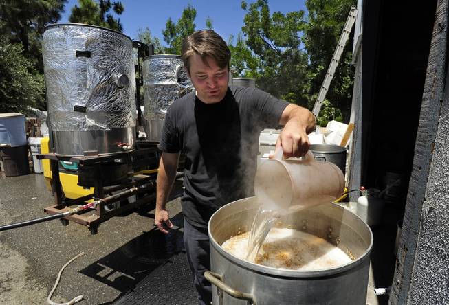 Army veteran Eric Johnson, of Fremont, Calif., pours hot water into the mash of Valor Double IPA at Uncle Sam's Misguided Brewery in Livermore, Calif., on Monday, May 26, 2014. The brewery is run by fellow veterans and co-owners Josh Laine and Fara Eve Barnes.