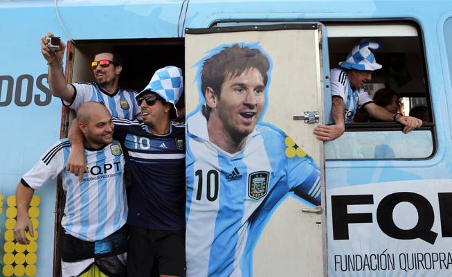 Argentine fans arrive in a bus decorated with a painting of soccer star Leonel Mesi at the Copacabana beach in Rio de Janeiro, Brazil, Saturday June 14, 2014. Waving flags and banners, more than a thousand Argentine fans, many dressed in their team's traditional blue and white, crowded the Copacabana beachfront ahead of Argentina's World Cup match against Bosnia-Herzegovina Sunday in Rio's iconic Maracana stadium.