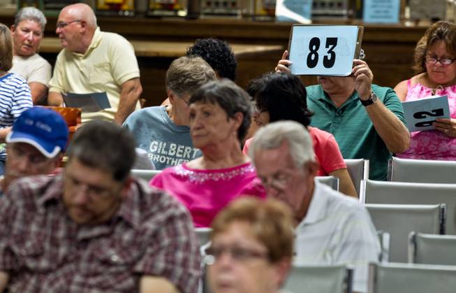 A bidder shows his number after winning an item during a one-day live auction hosted by Victorian Casino Antiques on Saturday, June 28, 2014. In cooperation with McManus Auctions, the showroom featured almost 600 lots of toys,.coin-operated machines, clocks, advertising art, gaming collectibles and much more.