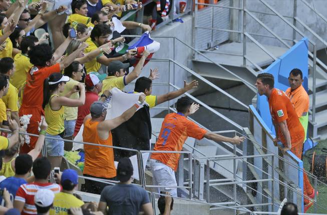 Netherlands' Klaas-Jan Huntelaar, right, celebrates with fans after scoring his side's second goal from the penalty spot during the World Cup round of 16 soccer match between the Netherlands and Mexico at the Arena Castelao in Fortaleza, Brazil, Sunday, June 29, 2014. Holland won 2-1 and advanced to the quarterfinal.