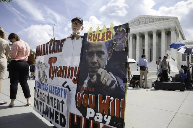 Ronald Brock moves his anti-Obamacare sign as protestors, press, and passersby wait for decisions in the final days of the Supreme Court's term, in Washington, Wednesday, June 25, 2014. The court has yet to announce its finding in Sebelius v. Hobby Lobby Stores. The chain of arts-and-crafts stores does not want to provide insurance coverage for certain forms of contraception that it finds objectionable on religious grounds. The justices ruled Wednesday that a startup Internet company has to pay broadcasters when it takes television programs from the airwaves and allows subscribers to watch them on smartphones and other portable devices.The justices said by a 6-3 vote that Aereo Inc. is violating the broadcasters' copyrights by taking the signals for free. (AP Photo/J. Scott Applewhite)