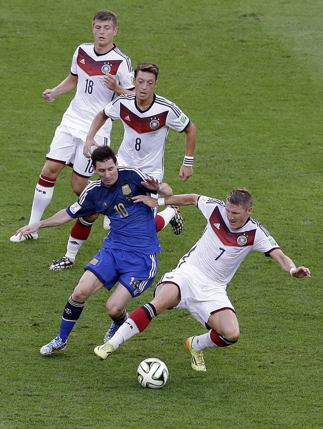 Argentina's Lionel Messi tries to control the ball past Germany's Bastian Schweinsteiger during the World Cup final soccer match between Germany and Argentina at the Maracana Stadium in Rio de Janeiro, Brazil, Sunday, July 13, 2014. Top is Germany's Toni Kroos and Germany's Mesut Ozil (8).