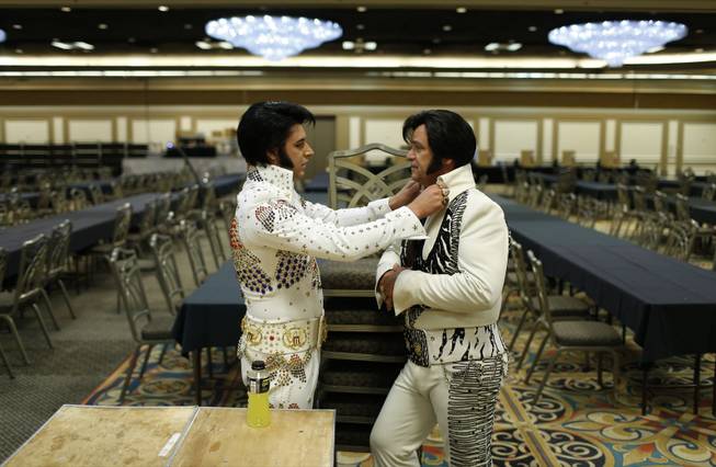 In this July 12, 2014 photo, Frank Werth, left, of Hays, Kan., looks at the collar of Tony Freitas, of Oakdale, Calif., during the Las Vegas Elvis Festival in Las Vegas. Some three dozen Elvis tribute artists took their gyrating hips and curled lips to the stage over the weekend to see who could do the most convincing portrayal.