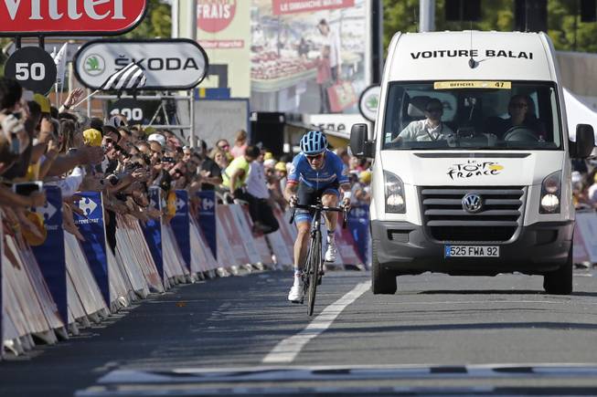 Andrew Talansky of the U.S. is accompanied by the "voiture balai" or "broom wagon" which sweeps up riders lagging behind as he arrives in the last 50 meters of the race of the eleventh stage of the Tour de France cycling race over 187.5 kilometers (116.5 miles) with start in Besancon and finish in Oyonnax, France, Wednesday, July 16, 2014.