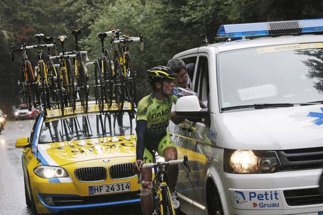 Spain's Alberto Contador gets medical assistance after crashing during the tenth stage of the Tour de France cycling race over 161.5 kilometers (100.4 miles) with start in Mulhouse and finish in La Planche des Belles Filles, France, Monday, July 14, 2014. Contador sustained a fractured shin and withdrew from the race.