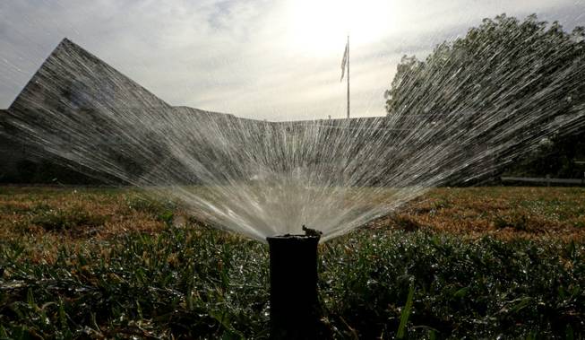 Sprinklers water a lawn July 15, 2014, in Sacramento. In an effort to force the public to conserve water, the State Water Resources Control Board voted 4-0 to approve a proposal that includes fines up to $500 a day for people who waste water on landscaping, fountains, washing vehicles and other outdoor uses.