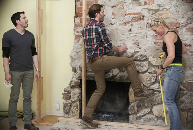 Interior designer Melissa Roche of Las Vegas competes in Season 2 of “Brother vs. Brother” on HGTV. Jonathan, center, points out to Roche and his twin brother Drew Scott that the fireplace still looked unfinished in the living room of the Hodge house in Northridge, Calif. Roche, part of Team Drew, was crowned the champion on the finale Sunday, July 13, 2014.