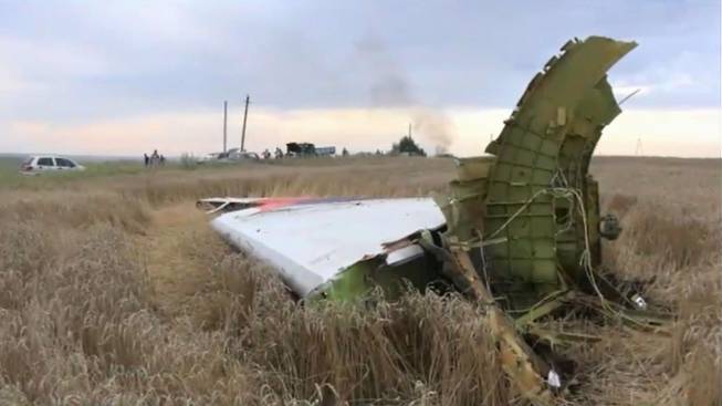 In this image taken from video, Thursday July 17, 2014, showing part of the wreckage of a passenger plane carrying 295 people was shot down Thursday as it flew over the country and plumes of black smoke rose up near a rebel-held village Hrabove, in eastern Ukraine. Malaysia Airlines tweeted that it lost contact with one of its flights as it was traveling from Amsterdam to Kuala Lumpur over Ukrainian airspace.