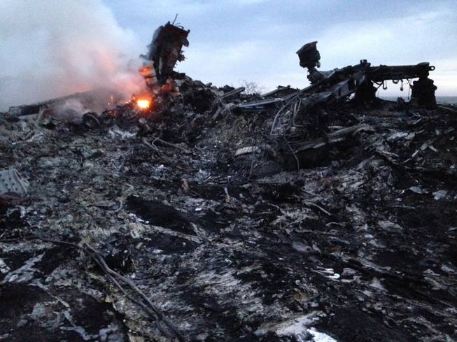 Smoke rises up at a crash site of a passenger plane, near the village of Grabovo, Ukraine, Thursday, July 17, 2014. A Ukrainian official said a passenger plane carrying 295 people was shot down Thursday as it flew over the country and plumes of black smoke rose up near a rebel-held village in eastern Ukraine. Malaysia Airlines tweeted that it lost contact with one of its flights as it was traveling from Amsterdam to Kuala Lumpur over Ukrainian airspace.