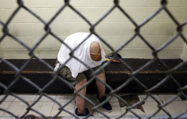 AP10ThingsToSee - In this June 26, 2014 photo, a U.S. veteran with post-traumatic stress, sits in a segregated holding pen at Chicago's Cook County Jail after he was arrested on a narcotics charge. The complex, with more than 10,600 inmates, is one of the country's largest single-site jails.