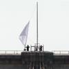 Photo: New York City Police officers lower a white flag f Photo: New York City Police officers lower a white flag f