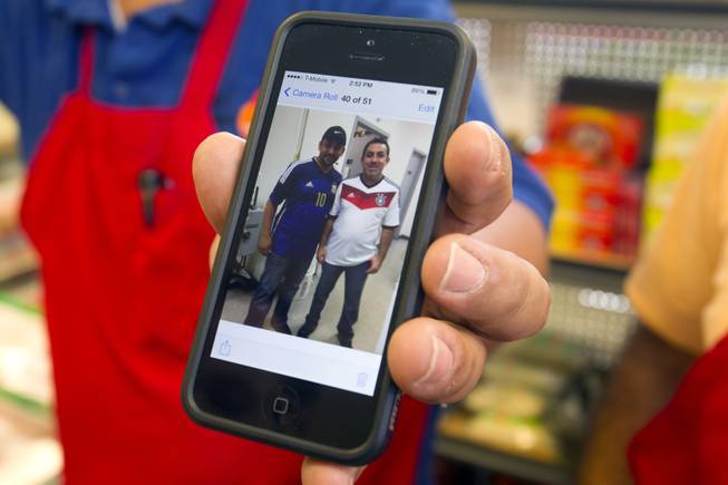 Ghazwan "Gino" Salem shows a photo of himself and Abdul Nasser Karouni at the Afandi Restaurant and Market, 5181 W. Charleston Blvd., Tuesday, July 15, 2014. The business partners supported opposing teams during the 2014 World Cup. Salem wears an Argentina jersey, Karouni wears a German jersey. STEVE MARCUS