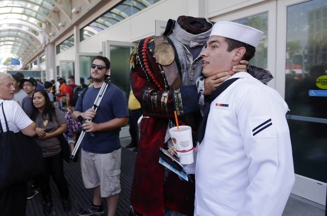 In this July 19, 2013, file photo, Navy Mineman Bradley Allred jokes as he has his picture taken with a headless character during Comic-Con, in San Diego. Like Batman responding to a beaming Bat signal in the sky, pop-culture fans are flocking to San Diego for the 45th annual Comic-Con. The four-day festival celebrating comic books, costumes and other popular arts kicks off with a preview Wednesday night, July 23, 2014, and goes full force Thursday, July 24, 2014, at the San Diego Convention Center.