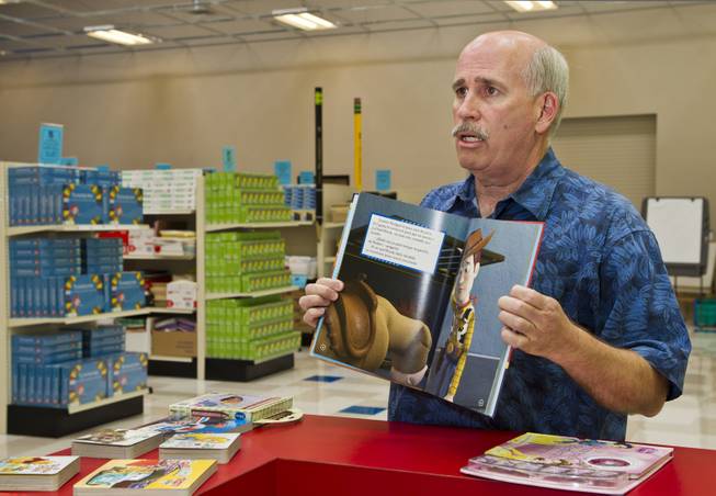 Tim McCubbin, director of the Public Education Foundation's Teacher EXCHANGE, displays one of the Spanish-language books available for teachers to purchase for cheap on Tuesday, July 22, 2014. They are very popular items and thousands have been purchased for first and second language students.