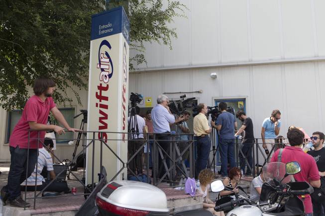 Journalists wait for news outside the Spanish Swiftair airline office in Madrid, Spain,Thursday, July 24, 2014. An Air Algerie flight carrying more than 100 people from Burkina Faso to Algeria's capital disappeared from radar early Thursday over northern Mali, officials said. France's foreign minister said no wreckage had been found, but that the plane "probably crashed." More than 50 French were onboard the plane along with 27 Burkina Faso nationals and passengers from a dozen other countries. The flight was being operated by Spanish airline Swiftair, the company said in a statement, and the plane belonged to Swiftair. The flight crew was Spanish.