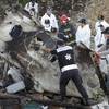 Photo: A forensic team recovers human remains among the w Photo: A forensic team recovers human remains among the w