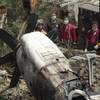 Photo: Emergency workers watch an engine lifted from the Photo: Emergency workers watch an engine lifted from the