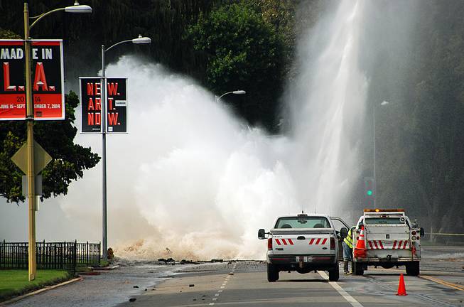 Water shoots in the air from a broken 30-inch water main under Sunset Boulevard, uphill from UCLA in the Westwood section of Los Angeles, Tuesday, July 29, 2014. The resulting flood inundated several areas of UCLA, including Pauley Pavilion, home of UCLA basketball, a parking structure and several other building.