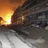 Photo: Tossed vehicles line an destroyed street as flames Photo: Tossed vehicles line an destroyed street as flames