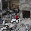 Photo: Palestinians inspect a destroyed house in the heav Photo: Palestinians inspect a destroyed house in the heav