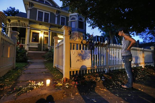 Angie Campbell stops to pay respects at a makeshift memorial outside the home where the 80s TV series Mork & Mindy, starring the late Robin Williams, was set, in Boulder, Colo., Monday Aug. 11, 2014. Robin Williams, the Academy Award winner and comic supernova whose explosions of pop culture riffs and impressions dazzled audiences for decades died Monday in an apparent suicide. He was 63.