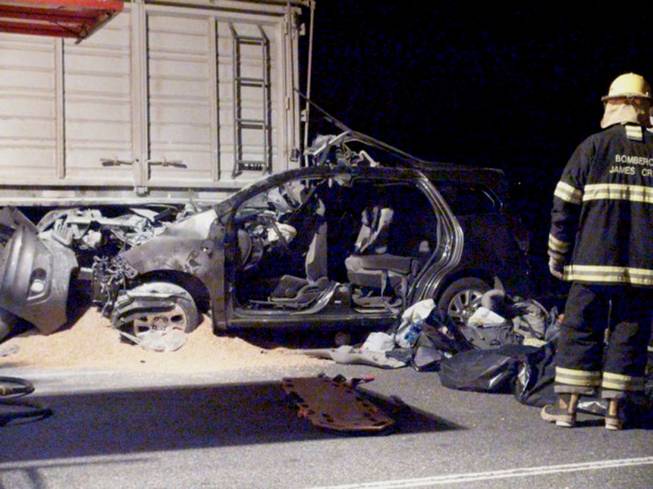 Firefighters inspect the car of Emanuel Bergoglio, nephew to Pope Francis, which crashed with a truck in James Craik, Argentina, early Tuesday, Aug. 19, 2014. Emanuel Bergoglio was seriously wounded as two young great-nephews of Pope Francis as well as their mother, the wife of the pope's nephew, were killed in the crash, according to the Vatican and a local police official.