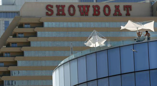 In this Wednesday, July 23, 2014, photo, people relax on a high deck at Revel resort near neighboring Showboat in Atlantic City. The state Gaming Enforcement Division gave final approval to Revel's shutdown on Sept. 1 and 2, signing the order Tuesday night and releasing it Wednesday, Aug. 20, 2014.