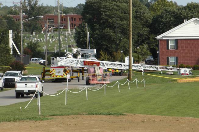 A Campbellsville Fire Department truck with the ladder extended remained at the scene where two firefighters were injured during an ice bucket challenge during a fundraiser for ALS on Thursday, Aug. 21, 2014, in Campbellsville, Ky. Officials say the ladder got too close to a power line and electricity traveled to the ladder, shocking the firefighters.