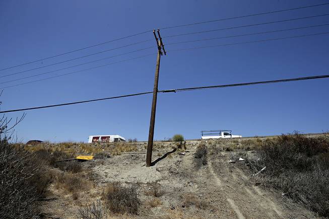 Debris and a newly-installed utility pole sit at the site of a fatal crash Friday, Aug. 22, 2014, in Oceanside, Calif. Three Japanese college students were killed and five other foreign students were injured late Thursday, when a car carrying them veered off a California freeway and struck a utility pole, officials said Friday.