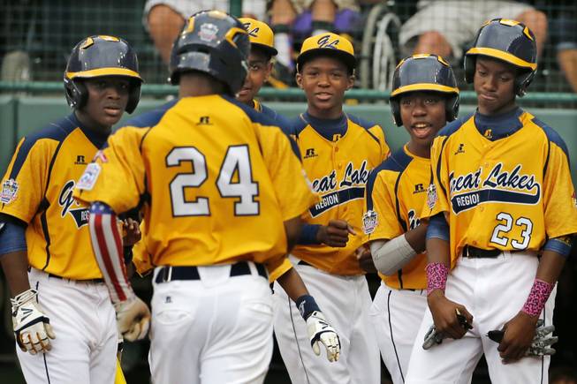 Chicago's Trey Hondras (24) is greeted by teammates after hitting a two-run home run off Las Vegas' Brennan Holligan in the first inning of a United States Championship game at the Little League World Series tournament in South Williamsport, Pa., Saturday, Aug. 23, 2014. (AP Photo/Gene J. Puskar