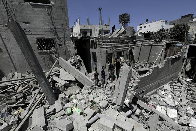 Palestinians, who are neighbors of a house belonging to Abu Hamada family, inspect the damage to their houses, after an Israeli strike in Jebaliya refugee camp, in the northern Gaza Strip, Monday, Aug. 25, 2014. Fifteen people were wounded in an airstrike on houses in Jebaliya refugee camp, according toGaza health official Ashraf al-Kidra.