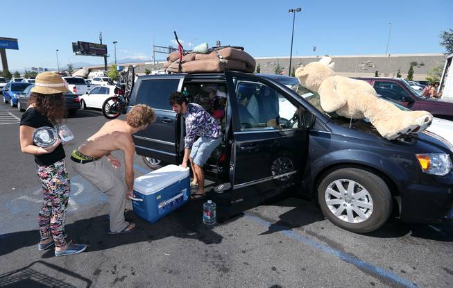 Burners, from left, Meyal Kashi, Avaid Furman and Ayal Moses, all from Isreal, stock up Tuesday, Aug. 26, 2014, at a Wal-Mart in Reno, Nev., after a rare rain storm temporarily closed the entrance to Burning Man yesterday. The Playa reopened at 6 a.m. for the weeklong counter-culture festival that draws 70,000 people to the Black Rock Desert.