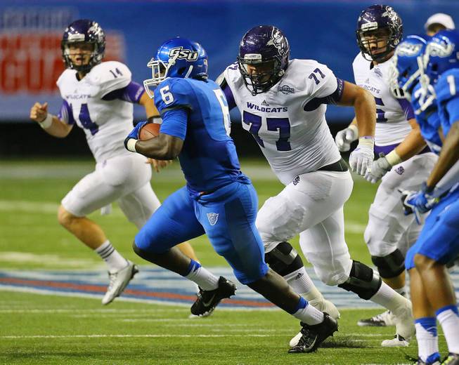 Georgia State linebacker Joseph Peterson runs back an interception of a pass by Abilene Christian quarterback Parker McKenzie, left rear, during the fourth quarter of an NCAA college football game in Atlanta on Wednesday, Aug. 27, 2014. The interception set up a Georgia State touchdown drive.