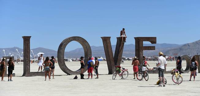 In this Aug. 27, 2014 photo, participants walk around at the Burning Man festival on the Black Rock Desert of Gerlach, Nev. Organizers call Burning Man the largest outdoor arts festival in North America, with its drum circles, decorated art cars, guerrilla theatrics and colorful theme camps.
