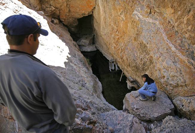FILE - This April 6, 2006 file photo shows Biologist Mike Bower, left, with the National Park Service, with Fish and Wildlife Service field supervisor Cynthia Martinez, in Devil's Hole, the endangered Devil's Hole Pupfish's only natural habitat, at Death Valley National Park in Nev. For 10,000 years, a tiny iridescent blue fish has lived in the depths of the cavern in Nevada's desert, but a new study says climate change and warming waters, and its lack of mobility, are threatening the pupfish and decreasing its numbers.