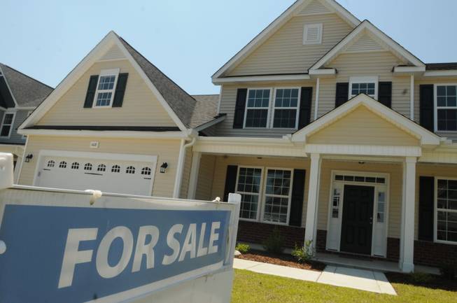 FILE - This June 19, 2014, file photo, shows a home for sale in Wilmington, N.C. Real estate data provider CoreLogic reports on U.S. home prices in July. In June, prices rose by the smallest year-over-year amount in 20 months, slowed by modest sales and more properties coming on the market. The slowing increases should make homes more affordable after prices had risen sharply last year. At the same time, Americans' pay hasn't risen nearly as fast.