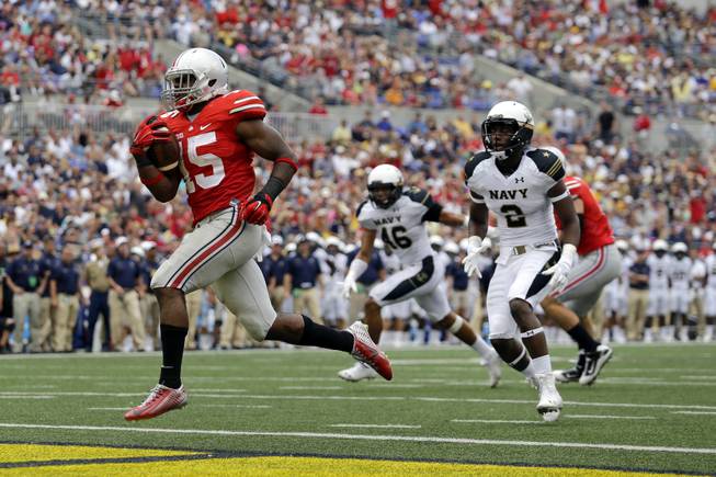 In this Aug. 30, 2014, file photo, Ohio State running back Ezekiel Elliott, left, runs past Navy safety Parrish Gaines (2) and linebacker Chris Johnson (46) for a touchdown in the second half of an NCAA college football game in Baltimore. After a 34-17 victory over Navy in the opener, coach Urban Meyer is pleased with the job done by Elliott, who gained 44 yards on 12 carries including this 10-yard touchdown run.