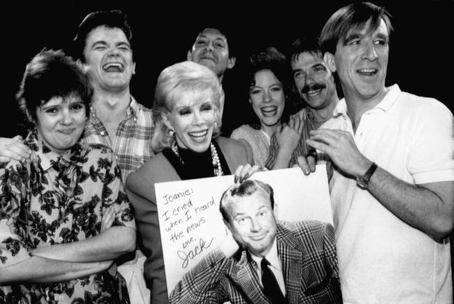 Comedian Joan Rivers, center, holds up a poster of Jack Paar, former host of NBC's "Tonight Show," which was given to her by the cast of National Lampoon's "Class of ?86" in New York, June 5, 1986. Rivers will host her own late night talk show this fall, competing with the "Tonight Show" and current host Johnny Carson. With Rivers are from left: Annie Golden, Rodger Bumpus, Tommy Koenig, Veanne Cox, John Michaels Higgins, and Brian Brucker O?Connor.