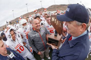 Bishop Gorman coach Tony Sanchez and his team are presented the championship trophy after the state championship game Saturday, Dec. 6, 2014, at Damonte Ranch High School in Reno. Gorman defeated Reed High 70-28 for the Gaels' sixth state title in a row.