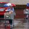 Photo: A woman keeps dry with an umbrella as she walks th Photo: A woman keeps dry with an umbrella as she walks th
