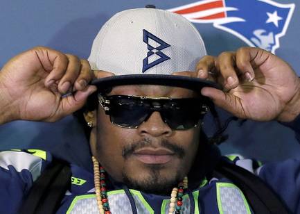 Seattle Seahawks' Marshawn Lynch adjusts his cap during an interview for Super Bowl XLIX on Thursday, Jan. 29, 2015, in Phoenix.