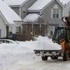 Photo: A worker uses a front-end loader to remove piled s Photo: A worker uses a front-end loader to remove piled s