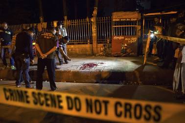 In this Thursday, Feb. 26, 2015, photo, Bangladeshi policemen investigate at the site of attack on Avijit Roy, in Dhaka, Bangladesh. Roy, a prominent Bangladeshi-American blogger, known for speaking out against religious fundamentalism was hacked to death in the streets of Bangladesh's capital as he walked with his wife, police said Friday.