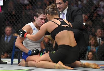 Ronda Rousey, right, consoles Cat Zingano after Zingano tapped out 14 seconds into a UFC 184 mixed martial arts bantamweight title bout Saturday, Feb. 28, 2015, in Los Angeles.