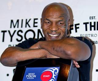 Former heavyweight boxing champion Mike Tyson stands with a Mike Tyson Bitcoin ATM in Off the Strip Bistro & Bar on Thursday, Sept. 24, 2015, at the Linq Promenade. The ATM allows consumers the ability to buy Bitcoins using a Bitcoin Wallet on mobile devices.